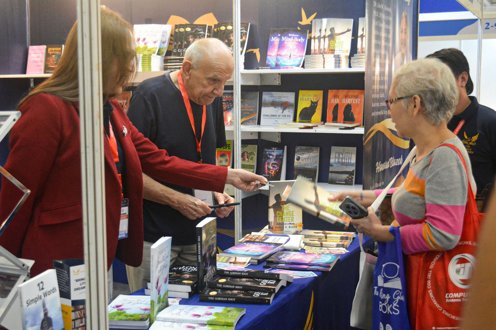 Visitors interacting with The Eagle Literary representatives while exploring featured books at the 2026 Manila International Book Fair, surrounded by published titles, promotional materials, and literary displays.